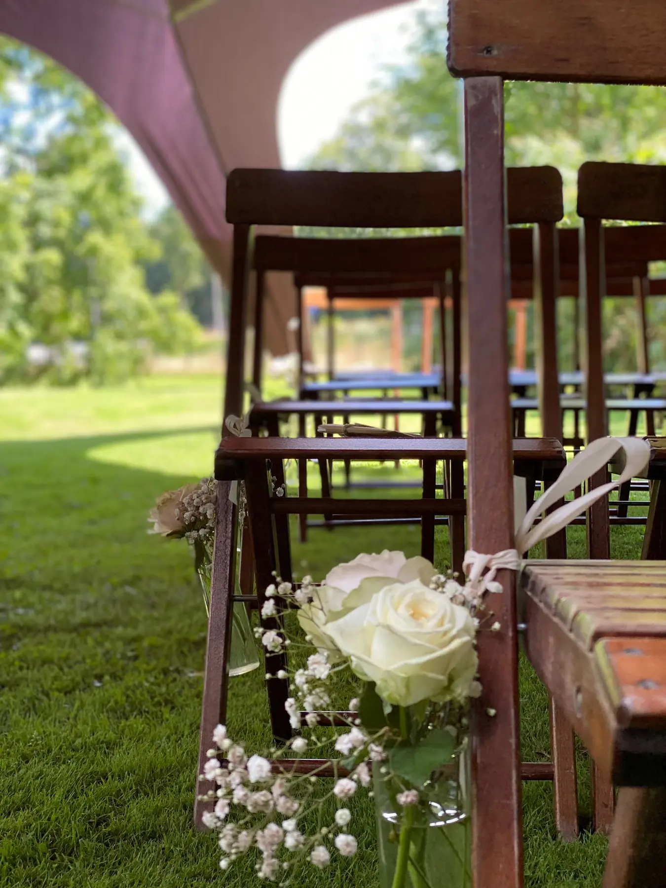 Stoelen met bloemen klaar voor een buitenceremonie